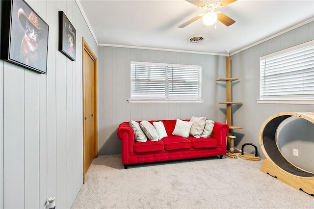 living area with ornamental molding, a wealth of natural light, and light colored carpet