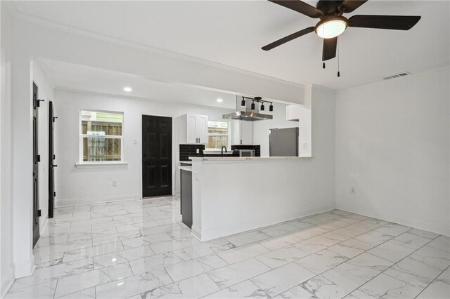 kitchen featuring stainless steel refrigerator, ceiling fan, kitchen peninsula, and white cabinets