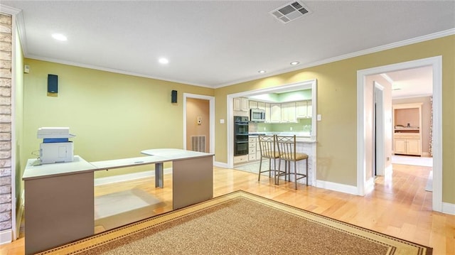 kitchen with a kitchen breakfast bar, black double oven, light hardwood / wood-style flooring, and crown molding