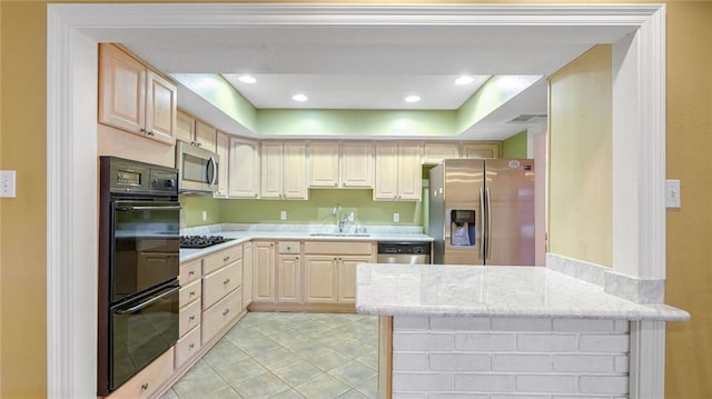 kitchen featuring light brown cabinets, kitchen peninsula, stainless steel appliances, and sink