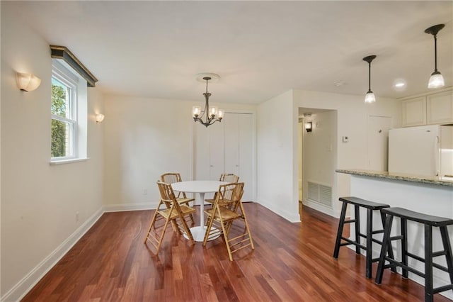 dining room featuring dark wood-type flooring and a chandelier