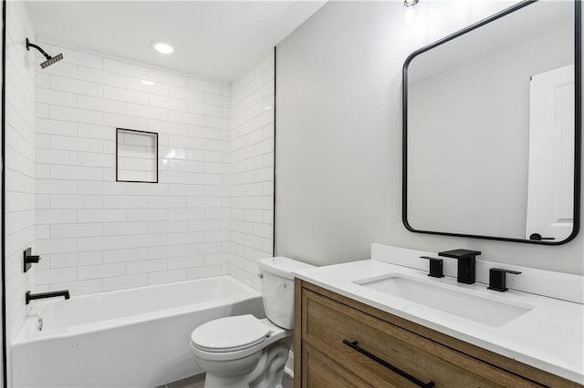 full bathroom featuring vanity, tiled shower / bath combo, and toilet