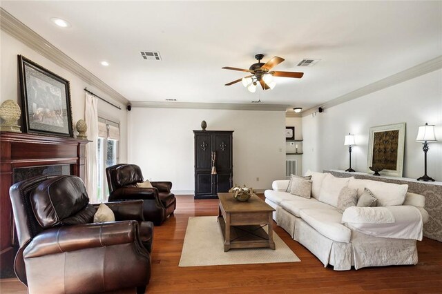 living room featuring dark wood-type flooring, ceiling fan, a healthy amount of sunlight, and a premium fireplace