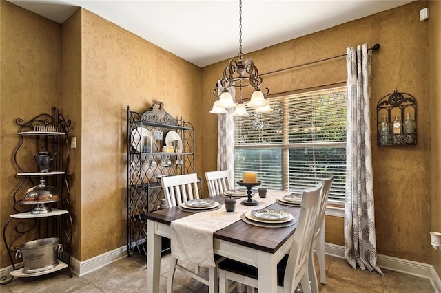 dining area with baseboards and a notable chandelier