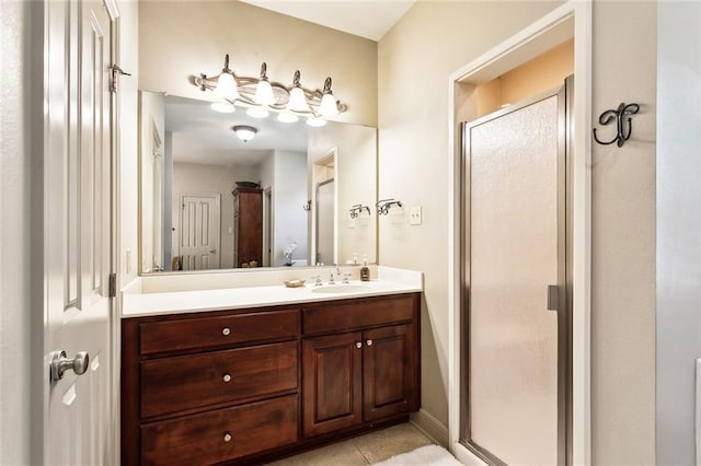 full bathroom with a stall shower, tile patterned floors, baseboards, and vanity