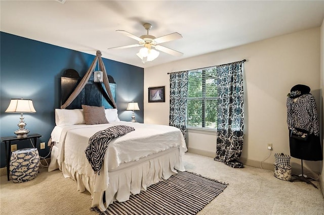 bedroom with a ceiling fan, light carpet, and baseboards