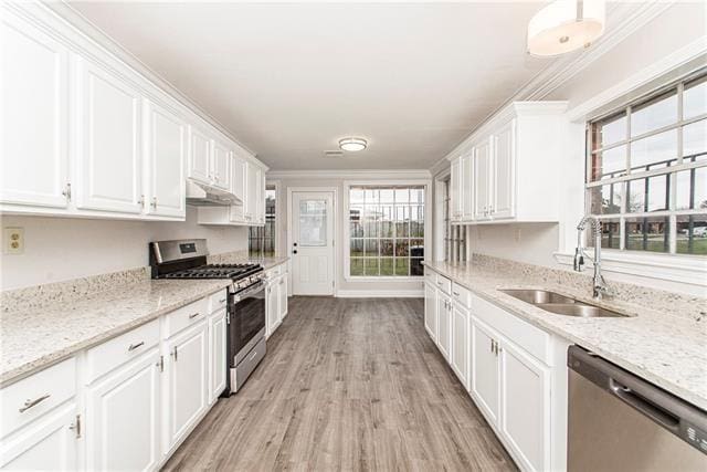 kitchen featuring stainless steel appliances, sink, light hardwood / wood-style flooring, crown molding, and white cabinets