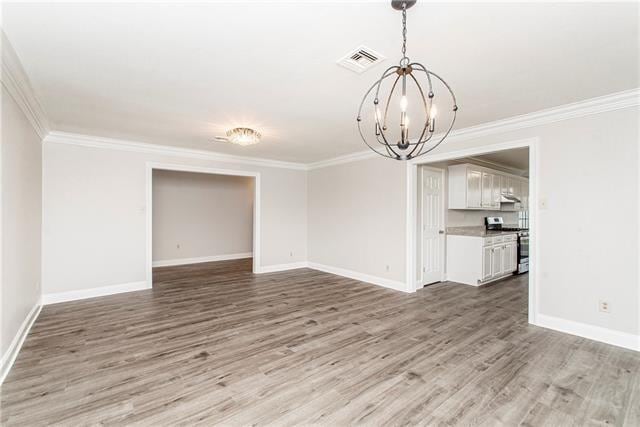 interior space featuring wood-type flooring, a chandelier, and crown molding