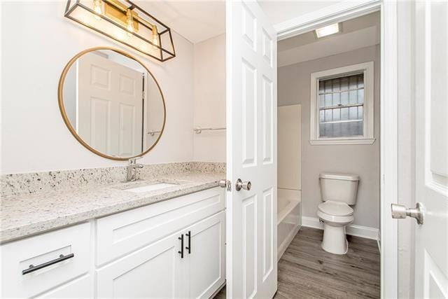 bathroom with toilet, vanity, and hardwood / wood-style flooring