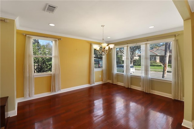 unfurnished dining area featuring crown molding, dark hardwood / wood-style floors, and a chandelier