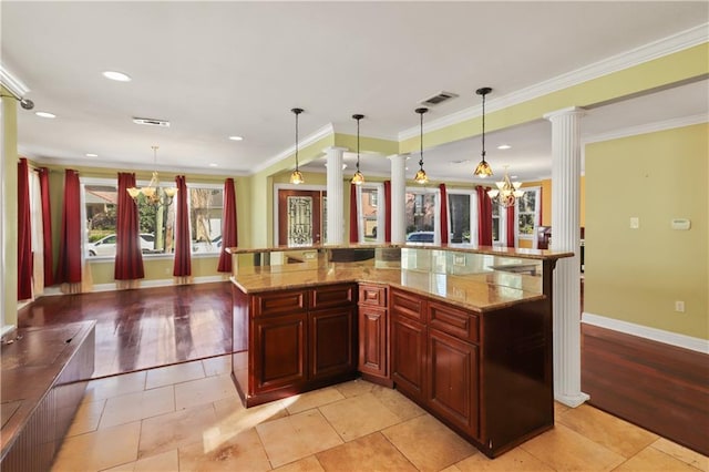 kitchen featuring an inviting chandelier, crown molding, light stone counters, hanging light fixtures, and light hardwood / wood-style flooring