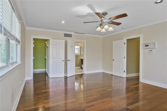 unfurnished bedroom with visible vents, multiple windows, ornamental molding, and wood finished floors