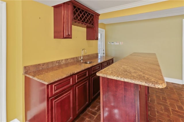 bar featuring ornamental molding, light stone countertops, and sink