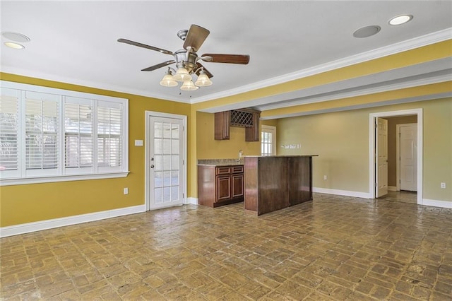 kitchen featuring brick floor, light countertops, ornamental molding, ceiling fan, and baseboards