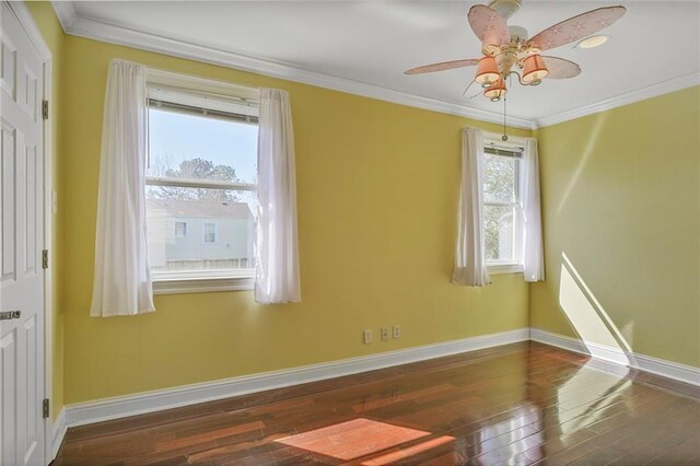 spare room featuring ornamental molding, a healthy amount of sunlight, and hardwood / wood-style flooring