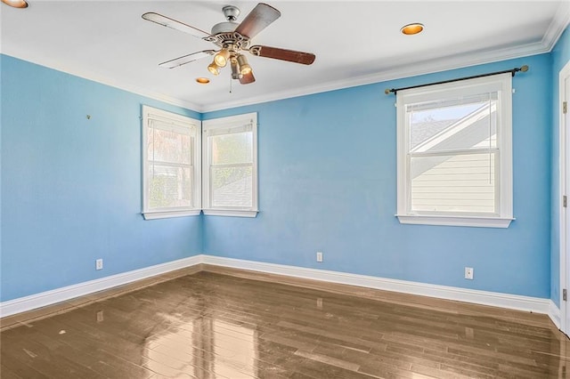 empty room with wood-type flooring, baseboards, and crown molding