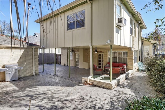 rear view of house featuring brick siding, a patio, a ceiling fan, fence, and an outdoor living space