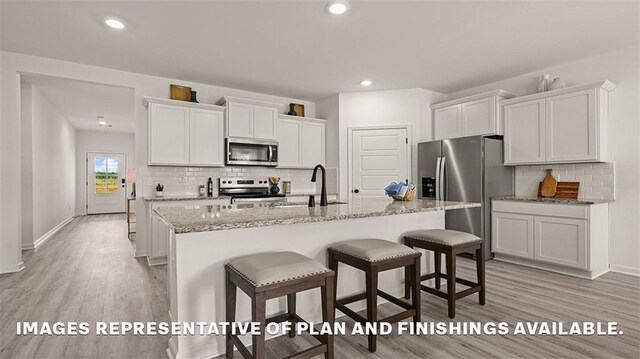24279 Gadwall Ave, Ponchatoula, LA 70454 - kitchen with appliances with stainless steel finishes, a sink, light wood-style flooring, tasteful backsplash, and recessed lighting