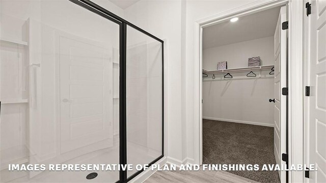 24279 Gadwall Ave, Ponchatoula, LA 70454 - bathroom featuring a shower stall, a walk in closet, and baseboards