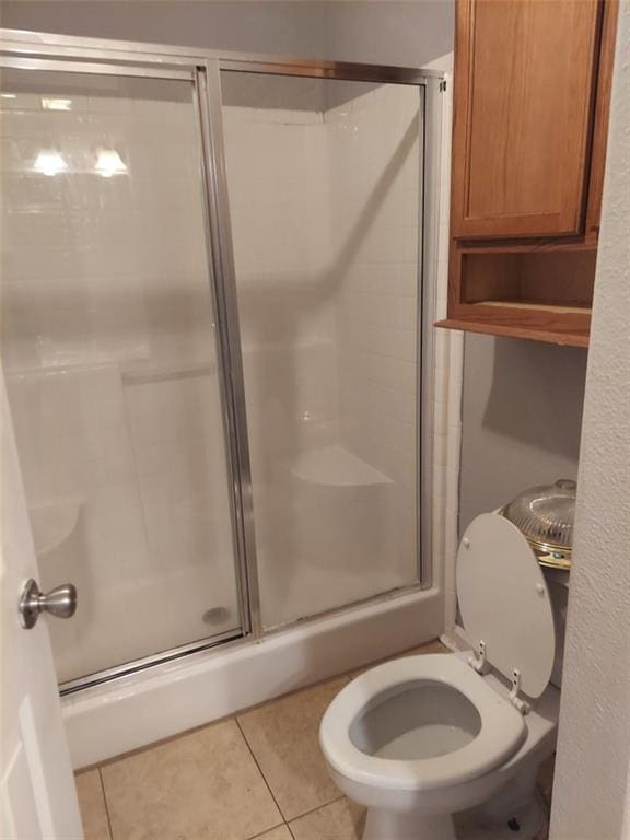 bathroom featuring toilet, tile patterned flooring, and walk in shower