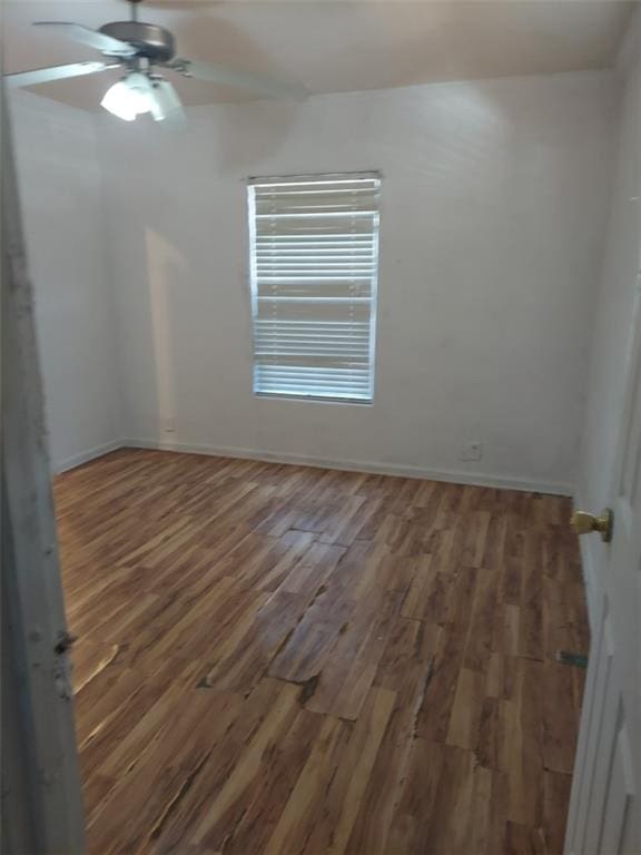 unfurnished room with ceiling fan and dark hardwood / wood-style flooring