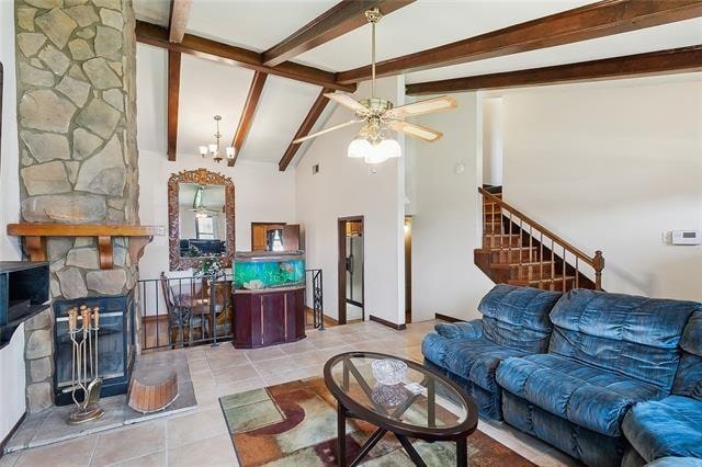 living room featuring beamed ceiling, ceiling fan, light tile patterned floors, and high vaulted ceiling