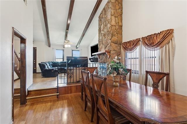 dining space with high vaulted ceiling, light hardwood / wood-style flooring, ceiling fan, and beam ceiling