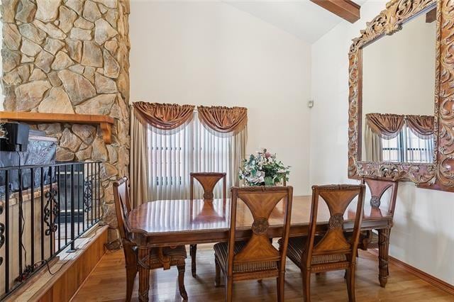 dining room featuring a wealth of natural light, hardwood / wood-style flooring, and vaulted ceiling with beams