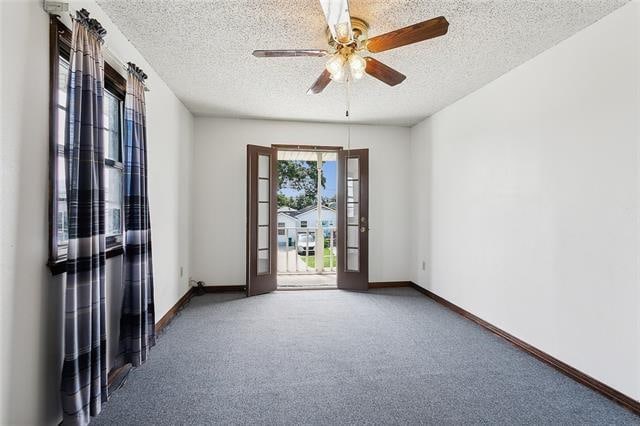 carpeted empty room featuring a textured ceiling and ceiling fan