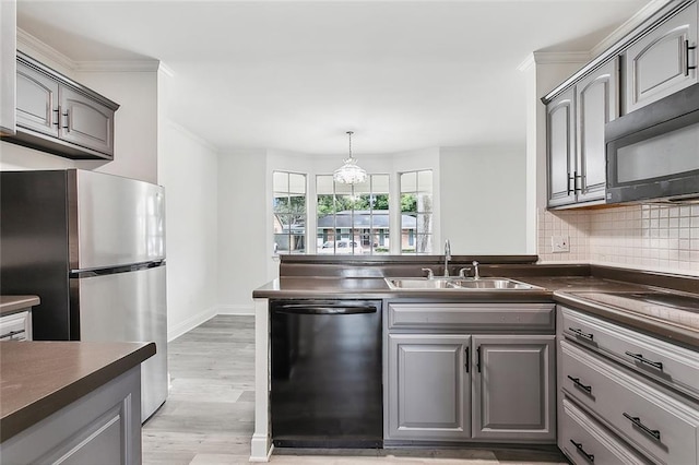 kitchen featuring dishwasher, stainless steel refrigerator, gray cabinetry, and sink