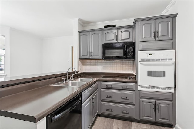 kitchen featuring gray cabinetry, black appliances, sink, light hardwood / wood-style flooring, and decorative backsplash