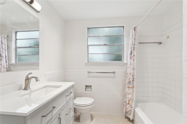 full bathroom with tile patterned floors, vanity, shower / bathtub combination with curtain, tile walls, and toilet