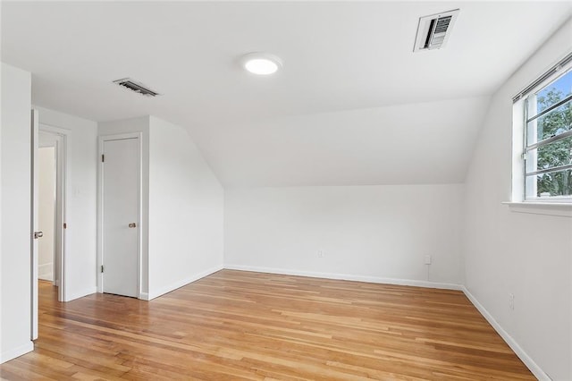 bonus room featuring wood-type flooring and vaulted ceiling