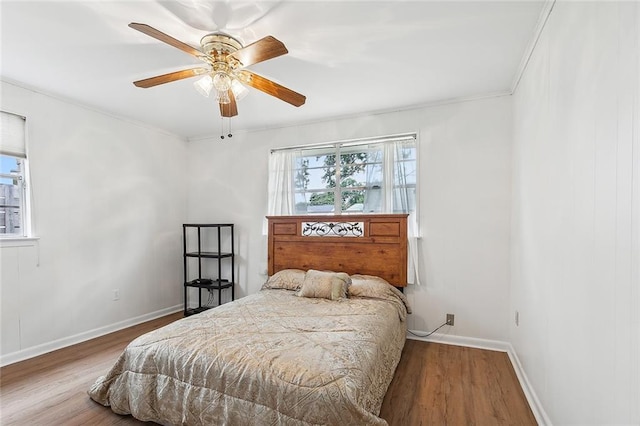 bedroom with ceiling fan, crown molding, and wood-type flooring