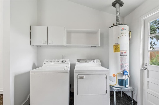 clothes washing area featuring cabinets, washing machine and dryer, and water heater