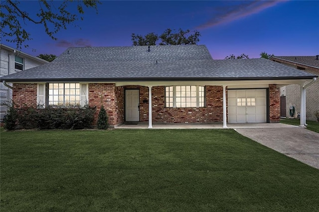 single story home featuring a garage and a lawn