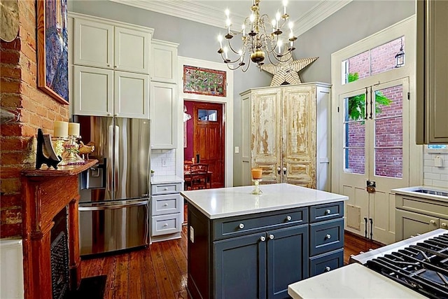 kitchen featuring tasteful backsplash, ornamental molding, stainless steel fridge, dark hardwood / wood-style flooring, and pendant lighting