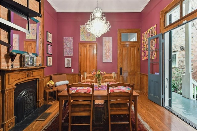 dining space featuring hardwood / wood-style flooring, ornamental molding, and a notable chandelier