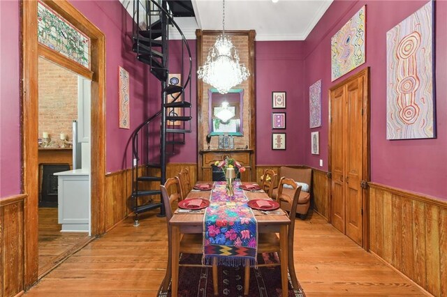 820B Saint Ann St, New Orleans, LA 70116 - dining room with a wainscoted wall, stairway, wood finished floors, wooden walls, and crown molding
