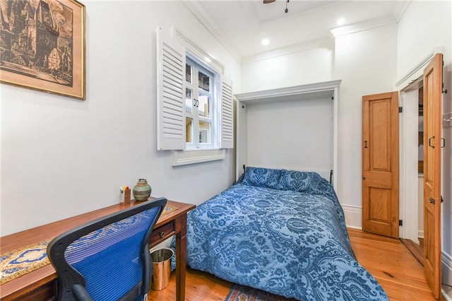 bedroom with hardwood / wood-style floors and ornamental molding