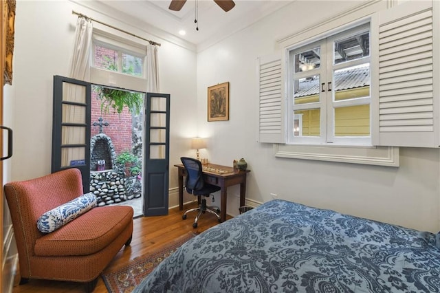 bedroom featuring hardwood / wood-style floors, ceiling fan, and crown molding