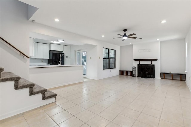 unfurnished living room with ceiling fan and light tile patterned floors