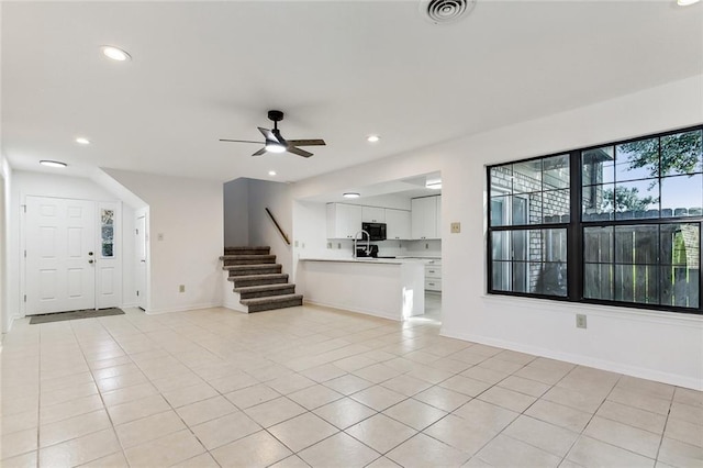 unfurnished living room with light tile patterned floors and ceiling fan