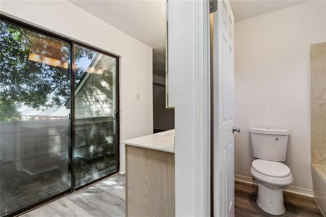 bathroom with hardwood / wood-style floors and toilet