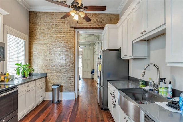 kitchen with white cabinets, dark hardwood / wood-style floors, brick wall, and stainless steel appliances