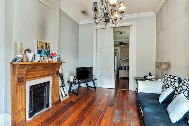 sitting room with dark wood-type flooring, ceiling fan with notable chandelier, and crown molding