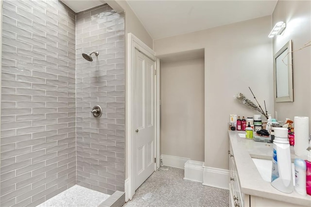 bathroom featuring tiled shower and vanity