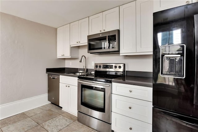 kitchen featuring stainless steel appliances, white cabinetry, sink, and light tile patterned floors