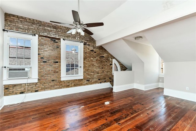 additional living space featuring brick wall, ceiling fan, cooling unit, vaulted ceiling with beams, and dark hardwood / wood-style flooring