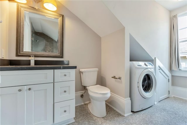 bathroom with vanity, washer / clothes dryer, vaulted ceiling, tile patterned flooring, and toilet